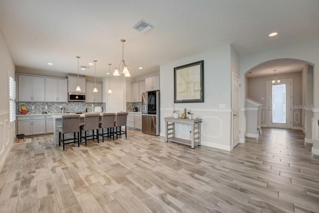 dining room with a wealth of natural light, light hardwood / wood-style floors, and a chandelier