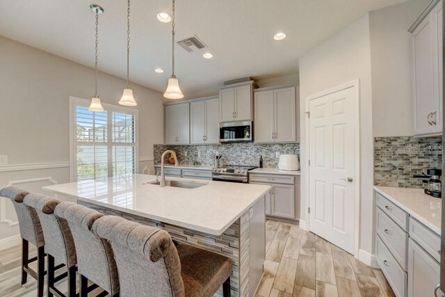 kitchen with backsplash, stainless steel appliances, and a breakfast bar area