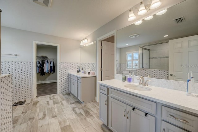 bathroom featuring vanity with extensive cabinet space, backsplash, and hardwood / wood-style flooring