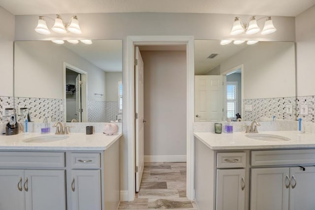 bathroom featuring wood-type flooring, backsplash, and vanity