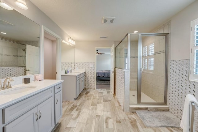 bathroom featuring an enclosed shower, oversized vanity, tile walls, and hardwood / wood-style floors