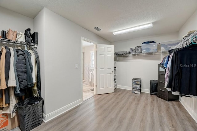 spacious closet with light hardwood / wood-style floors