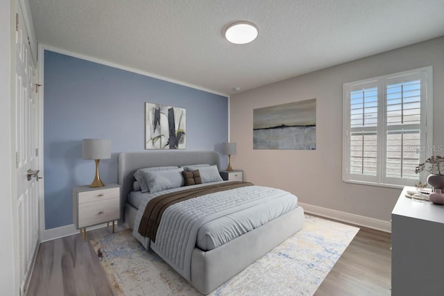 bedroom featuring hardwood / wood-style floors and a textured ceiling