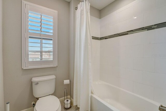 bathroom with toilet and shower / bath combo with shower curtain