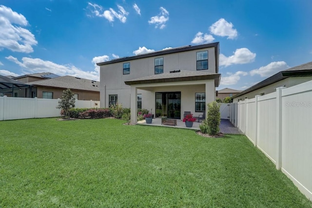 rear view of property featuring a patio area and a yard