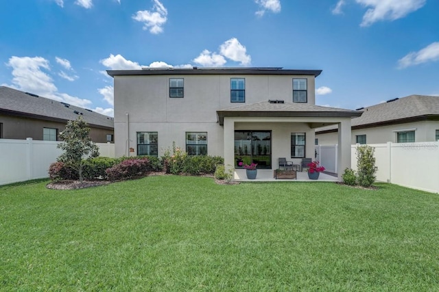 rear view of house with a patio and a yard