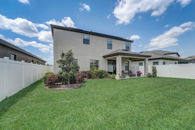 back of property with a patio area and a yard