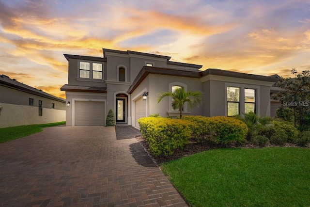 view of front of property featuring a garage and a lawn