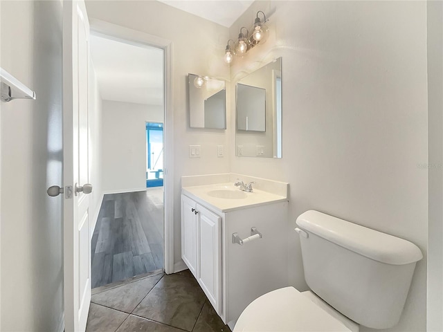 bathroom with toilet, hardwood / wood-style floors, and vanity