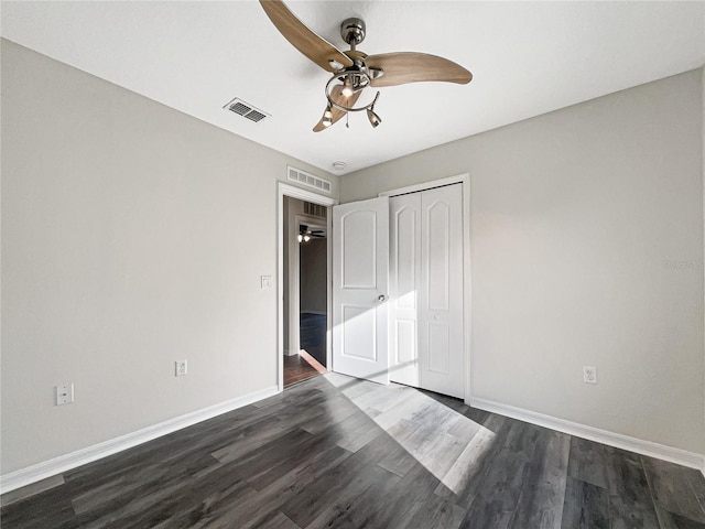 unfurnished bedroom featuring dark hardwood / wood-style flooring, a closet, and ceiling fan