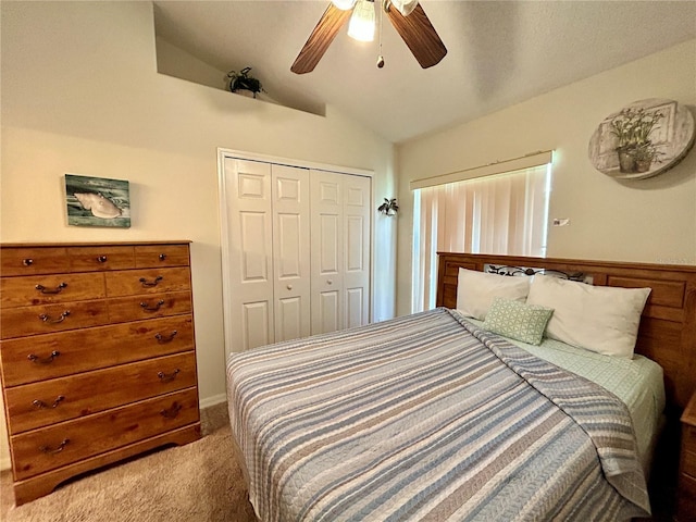 bedroom featuring light carpet, vaulted ceiling, a closet, and ceiling fan