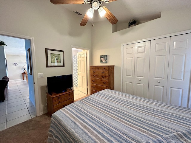 bedroom featuring ceiling fan, light tile patterned flooring, high vaulted ceiling, and a closet