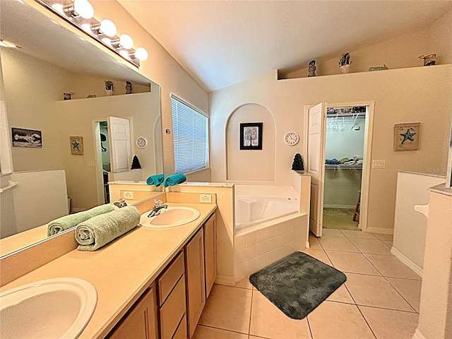 bathroom featuring tiled bath, tile patterned flooring, vanity, and lofted ceiling