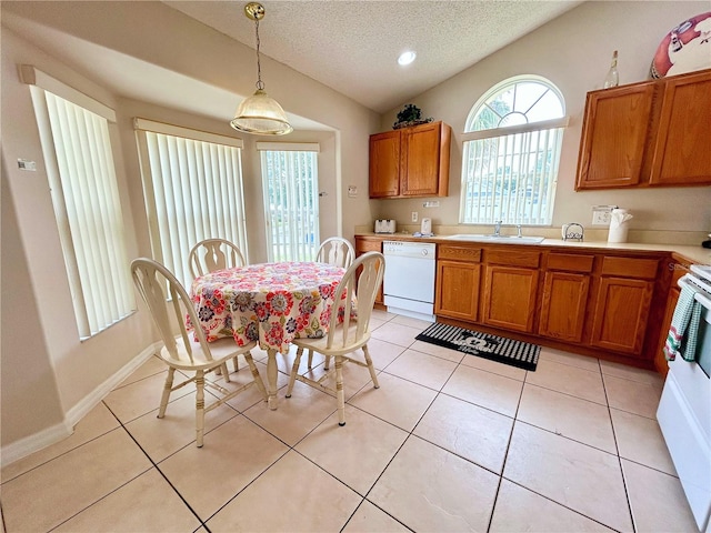 kitchen featuring a textured ceiling, white dishwasher, sink, pendant lighting, and light tile patterned floors