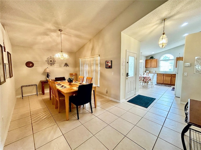 dining space with an inviting chandelier, light tile patterned floors, a textured ceiling, and vaulted ceiling