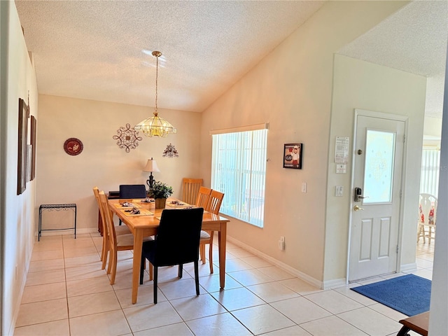 dining room with lofted ceiling, a textured ceiling, baseboards, an inviting chandelier, and light tile patterned flooring