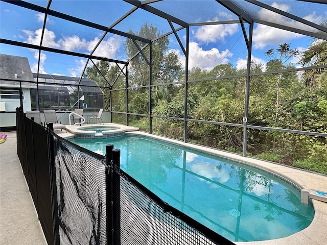 view of swimming pool featuring glass enclosure and a pool with connected hot tub