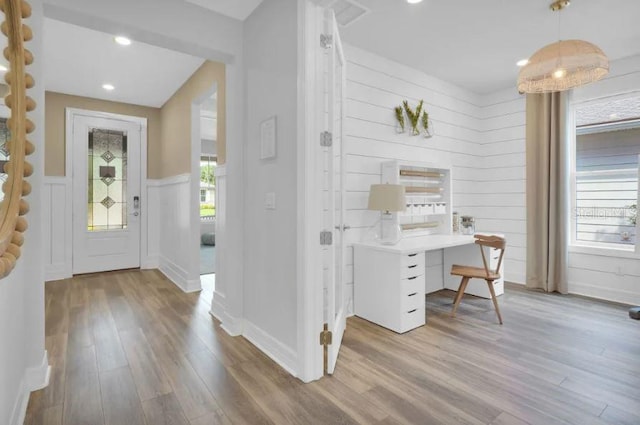 home office featuring wooden walls and light hardwood / wood-style floors