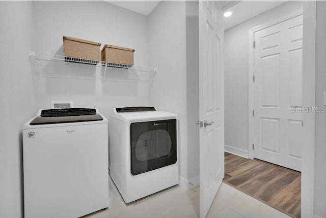 clothes washing area with washer and clothes dryer, hookup for a washing machine, and light tile flooring