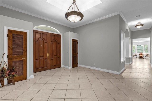 entrance foyer with light tile floors and ornamental molding