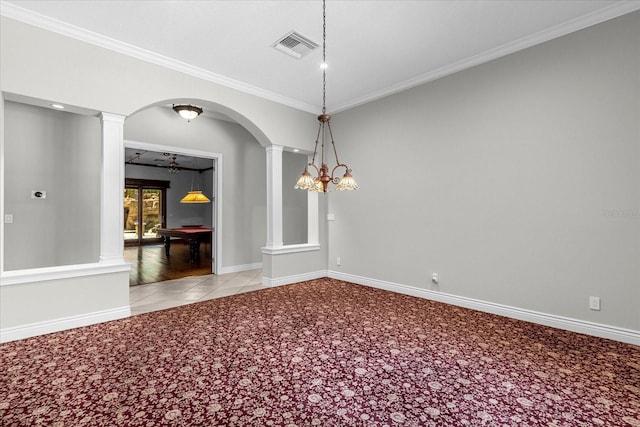 empty room featuring ornamental molding, light colored carpet, ornate columns, and ceiling fan with notable chandelier