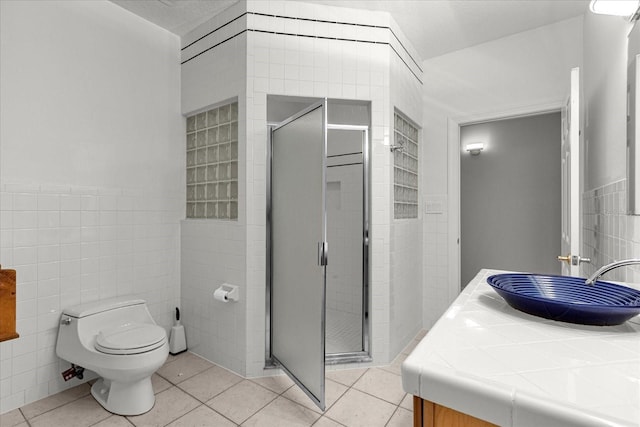 bathroom with tile walls, toilet, tile flooring, and vanity