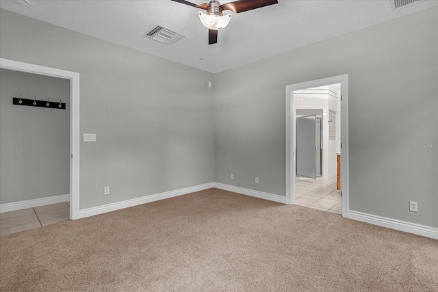 unfurnished room with a textured ceiling, ceiling fan, and light tile floors