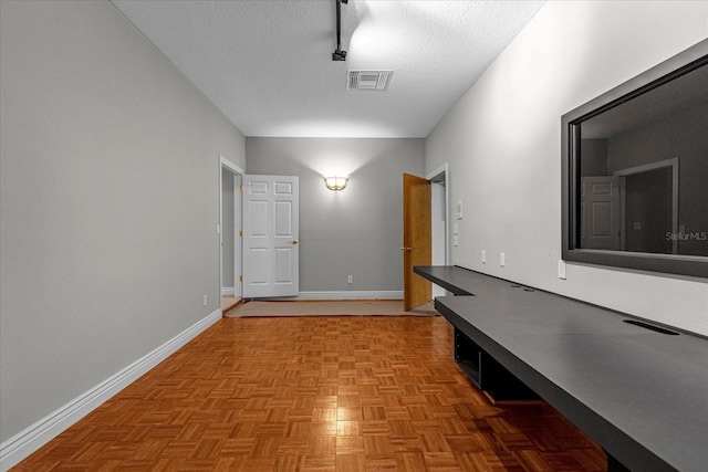 hall featuring light parquet flooring and a textured ceiling