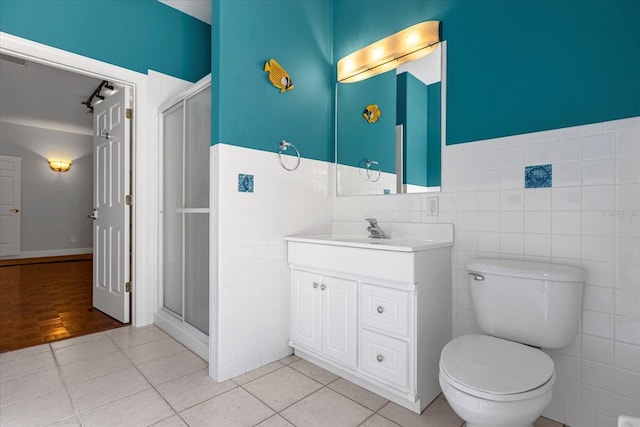 bathroom with hardwood / wood-style flooring, vanity, toilet, and tile walls