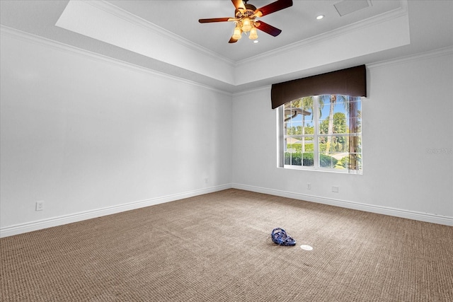 carpeted empty room featuring ornamental molding, ceiling fan, and a raised ceiling