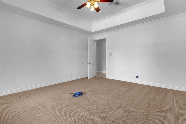 carpeted empty room featuring ceiling fan, crown molding, and a raised ceiling