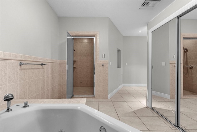 bathroom with shower with separate bathtub and tile floors