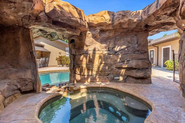 view of swimming pool with a jacuzzi