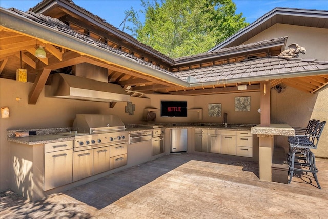 view of patio / terrace with a wet bar, area for grilling, and an outdoor kitchen