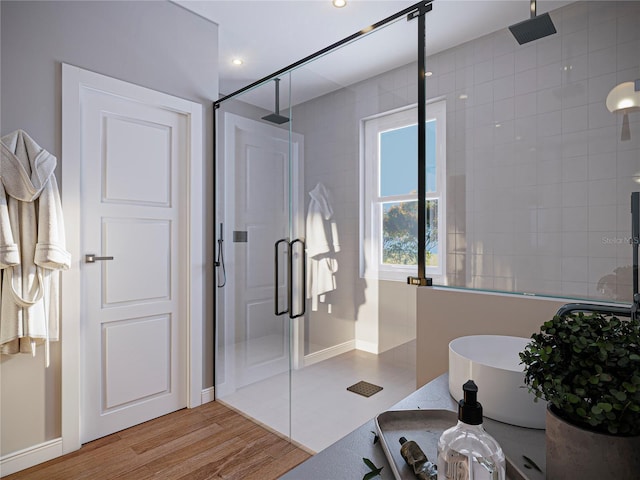 bathroom with hardwood / wood-style flooring and independent shower and bath