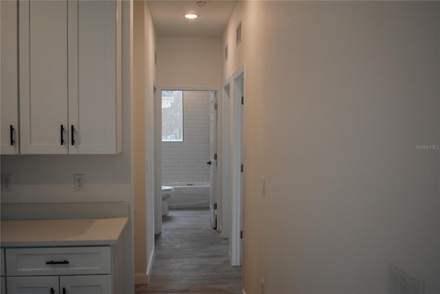 hallway featuring visible vents and wood finished floors