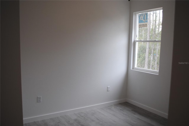 spare room featuring wood finished floors and baseboards