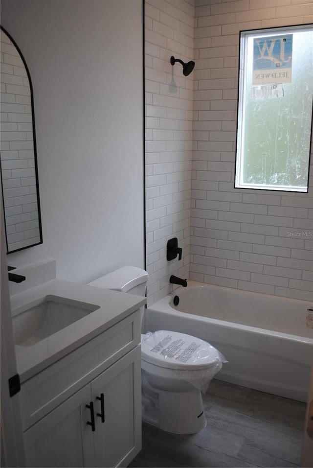 full bathroom with bathtub / shower combination, vanity, toilet, and wood finished floors