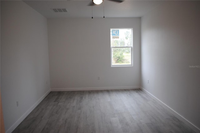 empty room with visible vents, baseboards, and wood finished floors