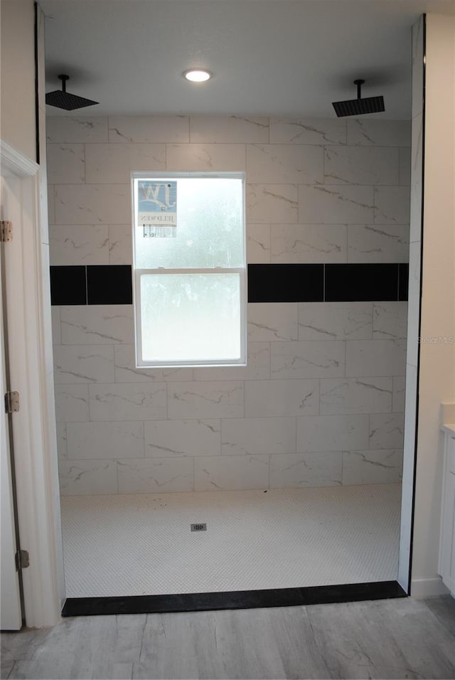 full bathroom featuring recessed lighting and a tile shower