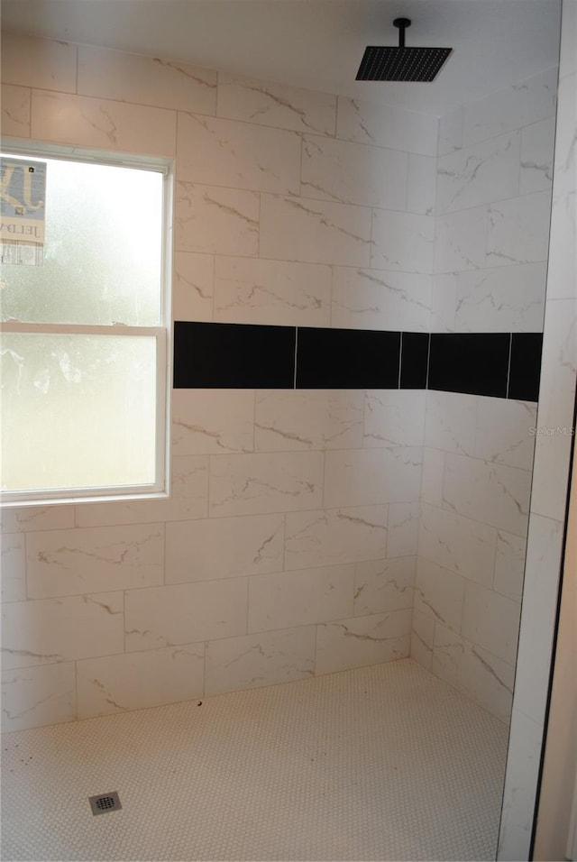 bathroom with a wealth of natural light and tiled shower