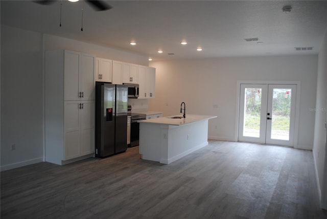 kitchen with visible vents, appliances with stainless steel finishes, wood finished floors, french doors, and a sink