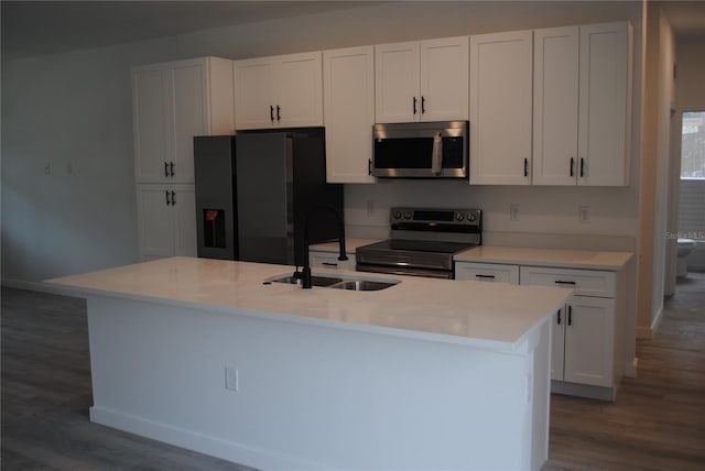 kitchen featuring white cabinetry, a center island with sink, appliances with stainless steel finishes, and a sink