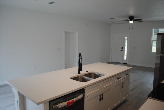 kitchen with black dishwasher, open floor plan, light wood-style floors, white cabinetry, and a sink