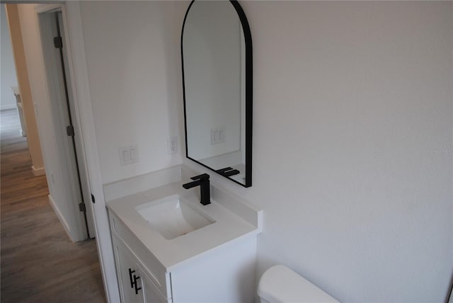 bathroom with vanity, toilet, and wood finished floors