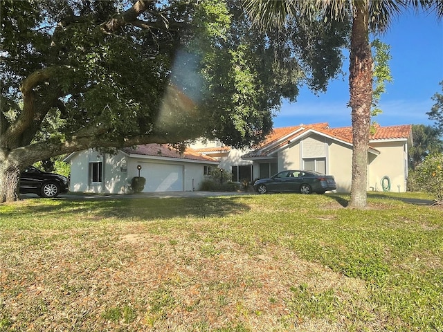 back of property with a lawn and a garage