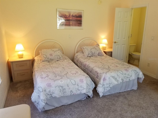 bedroom with dark colored carpet and ensuite bathroom