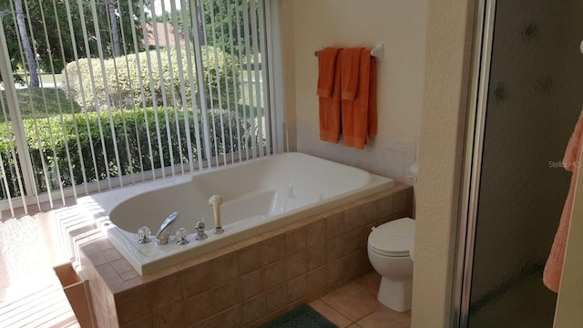 bathroom featuring tile floors, toilet, and plus walk in shower