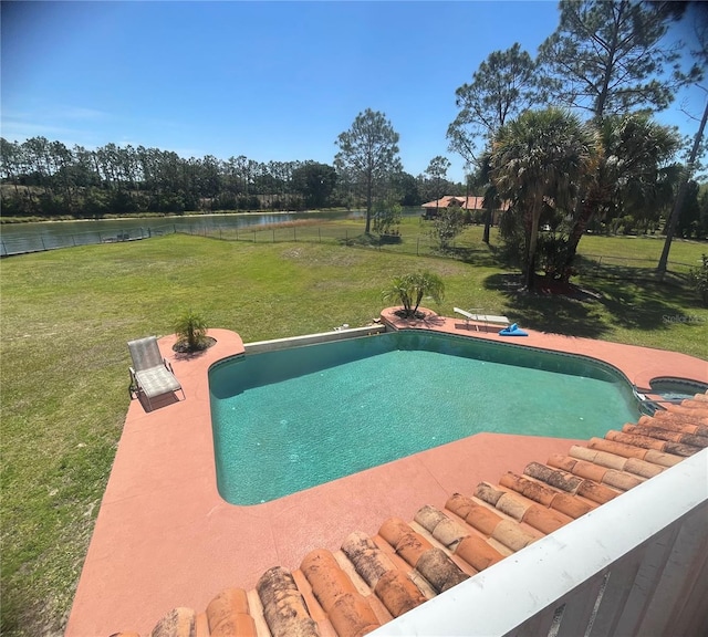 view of swimming pool with a yard and a water view