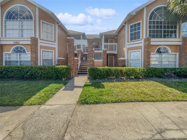 view of front of property with a front yard and a balcony